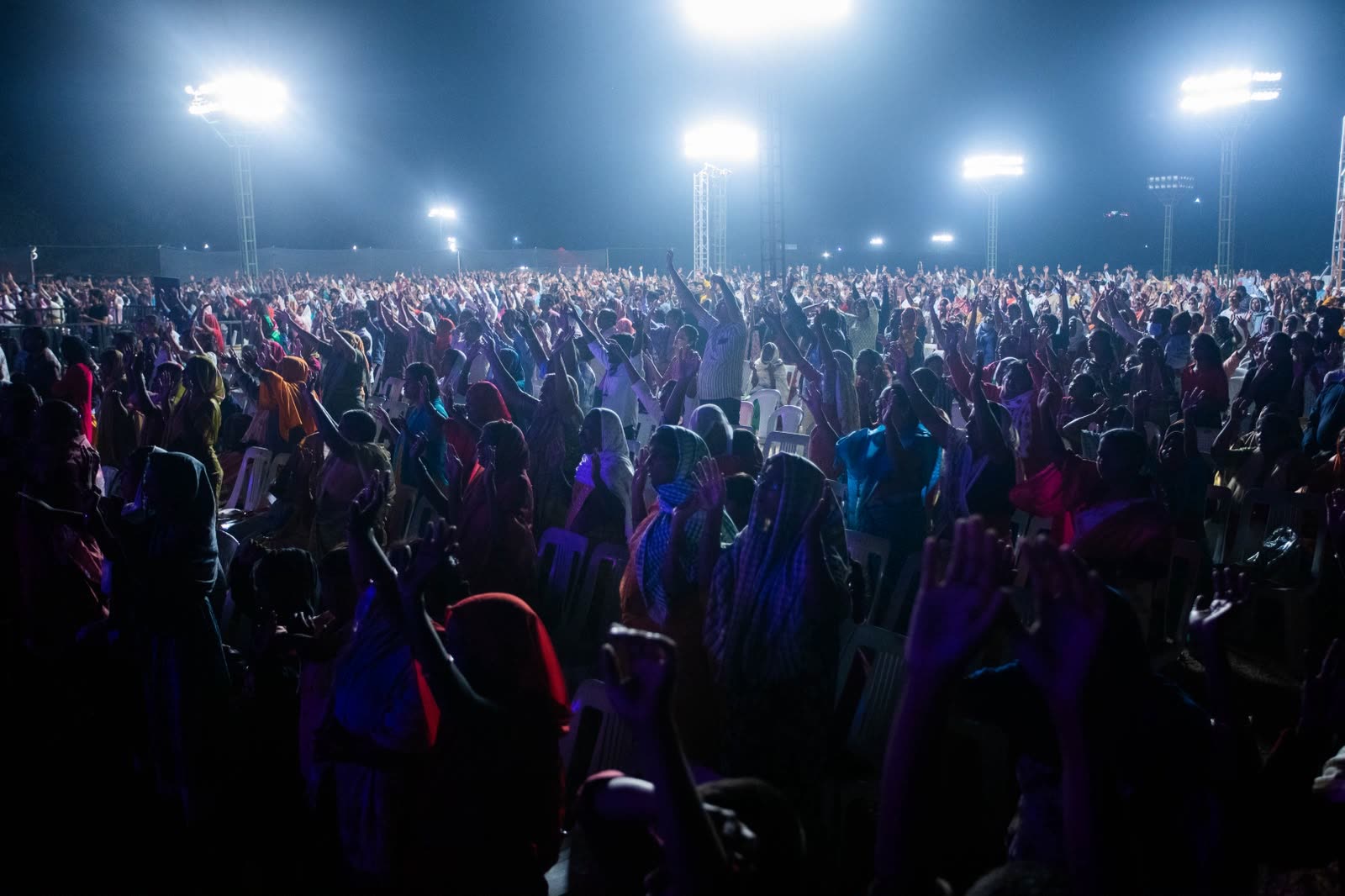 Congregation gathered under bright lights